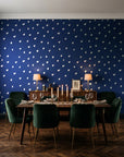 Caramel Haze Navy brushstroke dot wallpaper in a dark moody dining room with a candlelit table