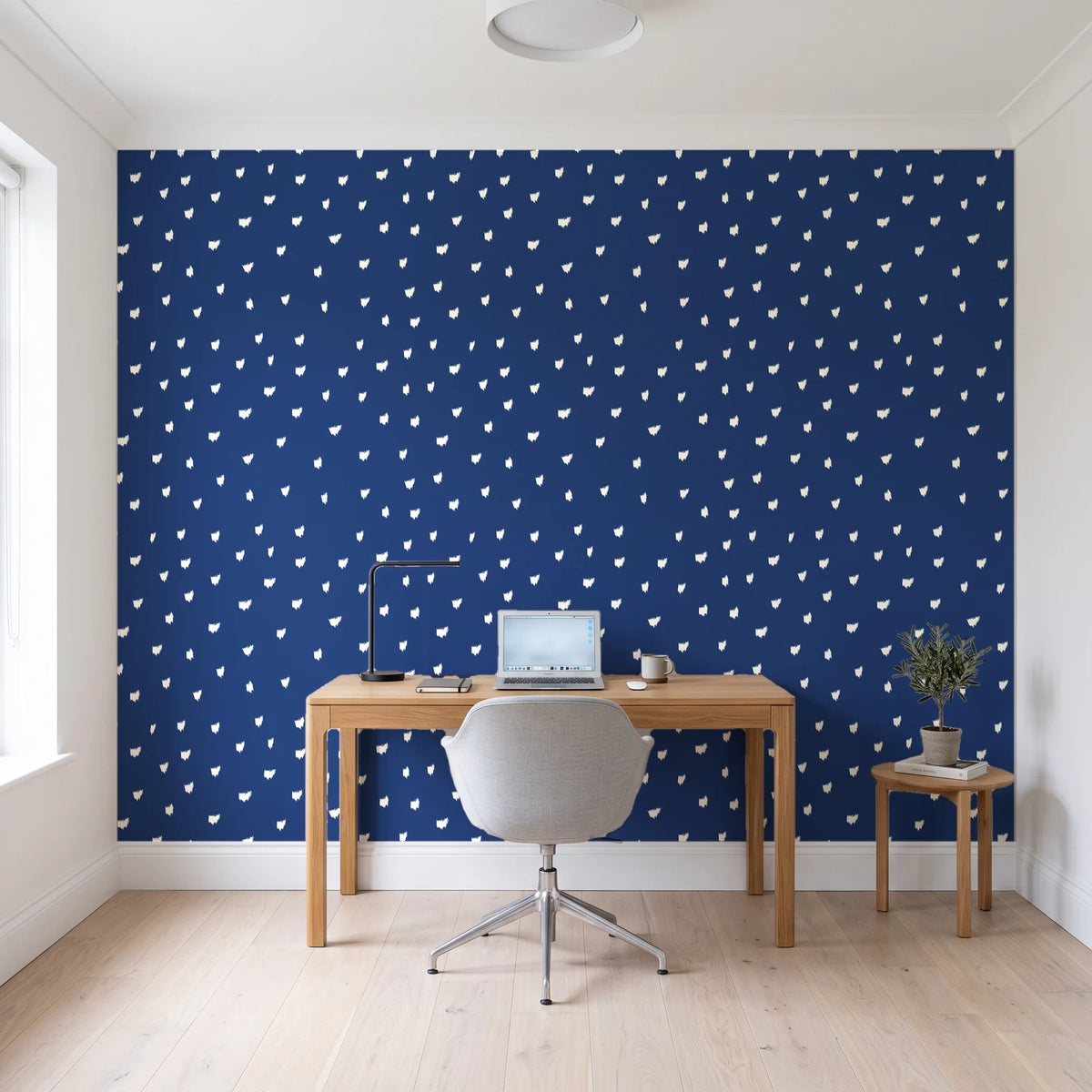 Caramel Haze Navy brushstroke dot wallpaper behind a modern oak desk in a bright home office