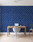 Caramel Haze Navy brushstroke dot wallpaper behind a modern oak desk in a bright home office