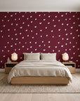 Caramel Haze Oxblood brushstroke dot wallpaper behind a low platform bed in a serene Japandi bedroom