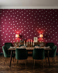 Caramel Haze Oxblood brushstroke dot wallpaper in a dark moody dining room with a candlelit table