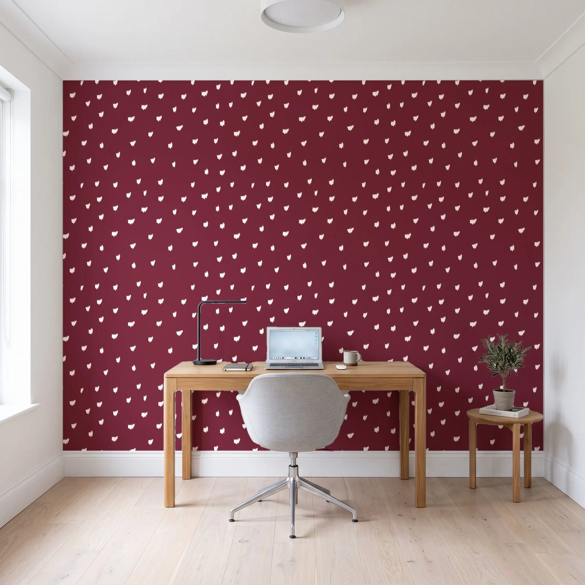 Caramel Haze Oxblood brushstroke dot wallpaper behind a modern oak desk in a bright home office