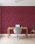 Caramel Haze Oxblood brushstroke dot wallpaper behind a modern oak desk in a bright home office
