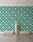 Carbon Bloom Emerald tile floral wallpaper behind a travertine pedestal and vase in a minimal boutique