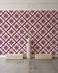 Carbon Bloom Oxblood tile floral wallpaper behind a travertine pedestal and vase in a minimal boutique