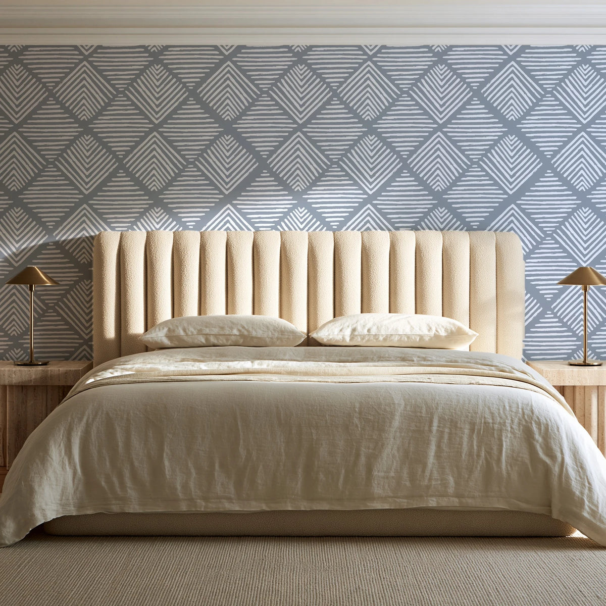 Chevron Etch Pewter geometric diamond wallpaper behind a channel-tufted bed in a calm primary bedroom
