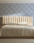 Chevron Etch Pewter geometric diamond wallpaper behind a channel-tufted bed in a calm primary bedroom