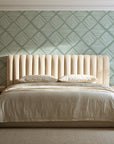 Chevron Etch Sage geometric diamond wallpaper behind a channel-tufted bed in a calm primary bedroom