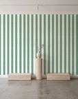 Citrine Column Emerald stripe wallpaper behind a travertine pedestal and vase in a minimal boutique