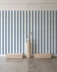Citrine Column Navy stripe wallpaper behind a travertine pedestal and vase in a minimal boutique