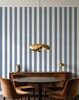 Citrine Column Navy stripe wallpaper behind a walnut credenza and round table in an elegant dining room