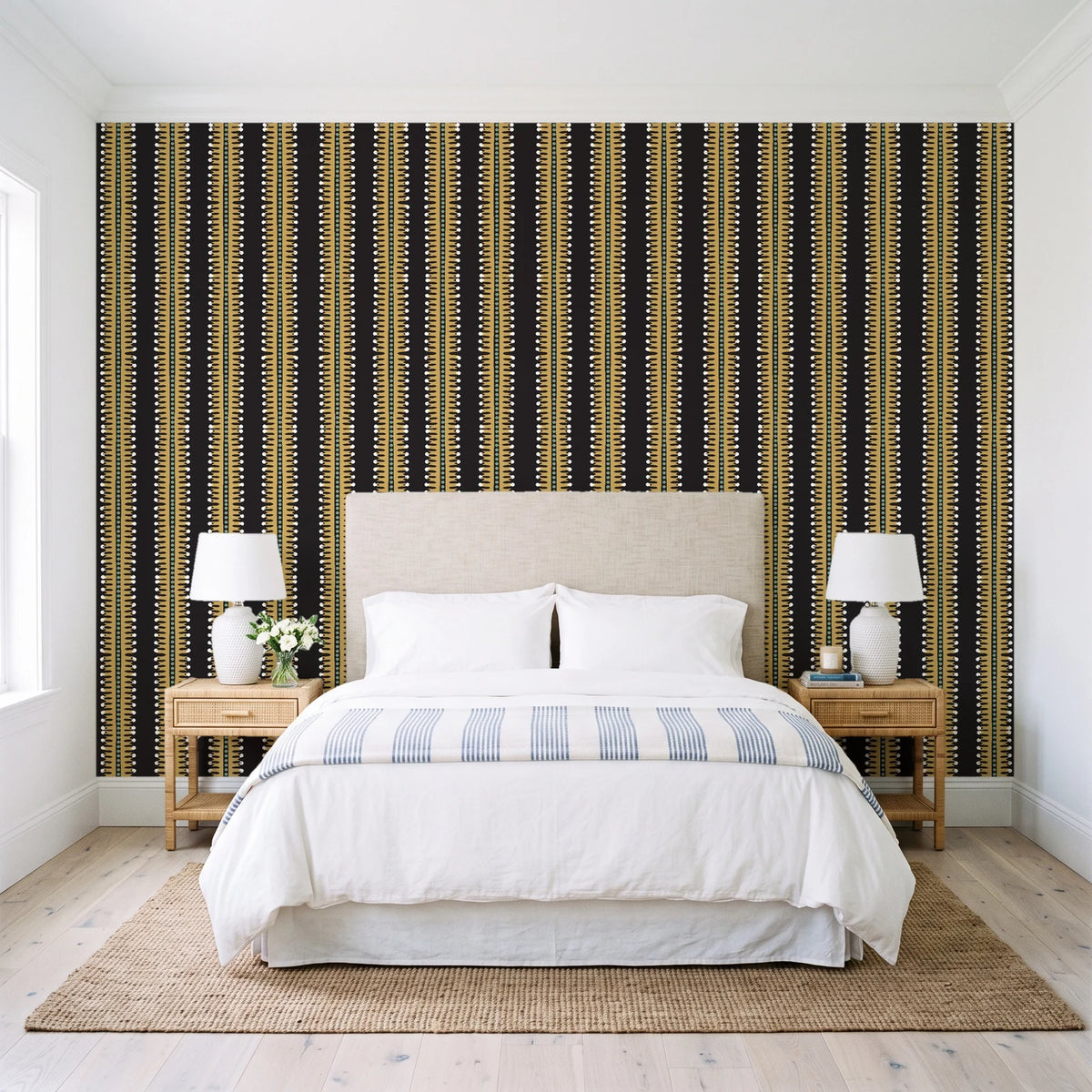 Citrine Column Noir stripe wallpaper behind a queen bed in a bright coastal bedroom
