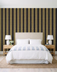 Citrine Column Noir stripe wallpaper behind a queen bed in a bright coastal bedroom