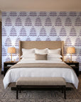 Clipped Dreams Plum tree wallpaper behind the headboard of a king bed in a contemporary hotel guest room