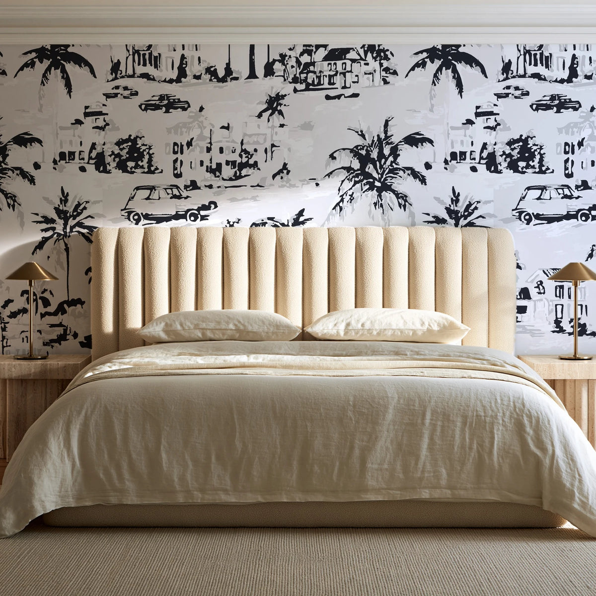 Coastal Village Charcoal palm toile wallpaper behind a channel-tufted bed in a calm primary bedroom