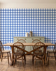 Cotton Candy Navy gingham wallpaper in a farmhouse dining room with a sage sideboard and rustic trestle table