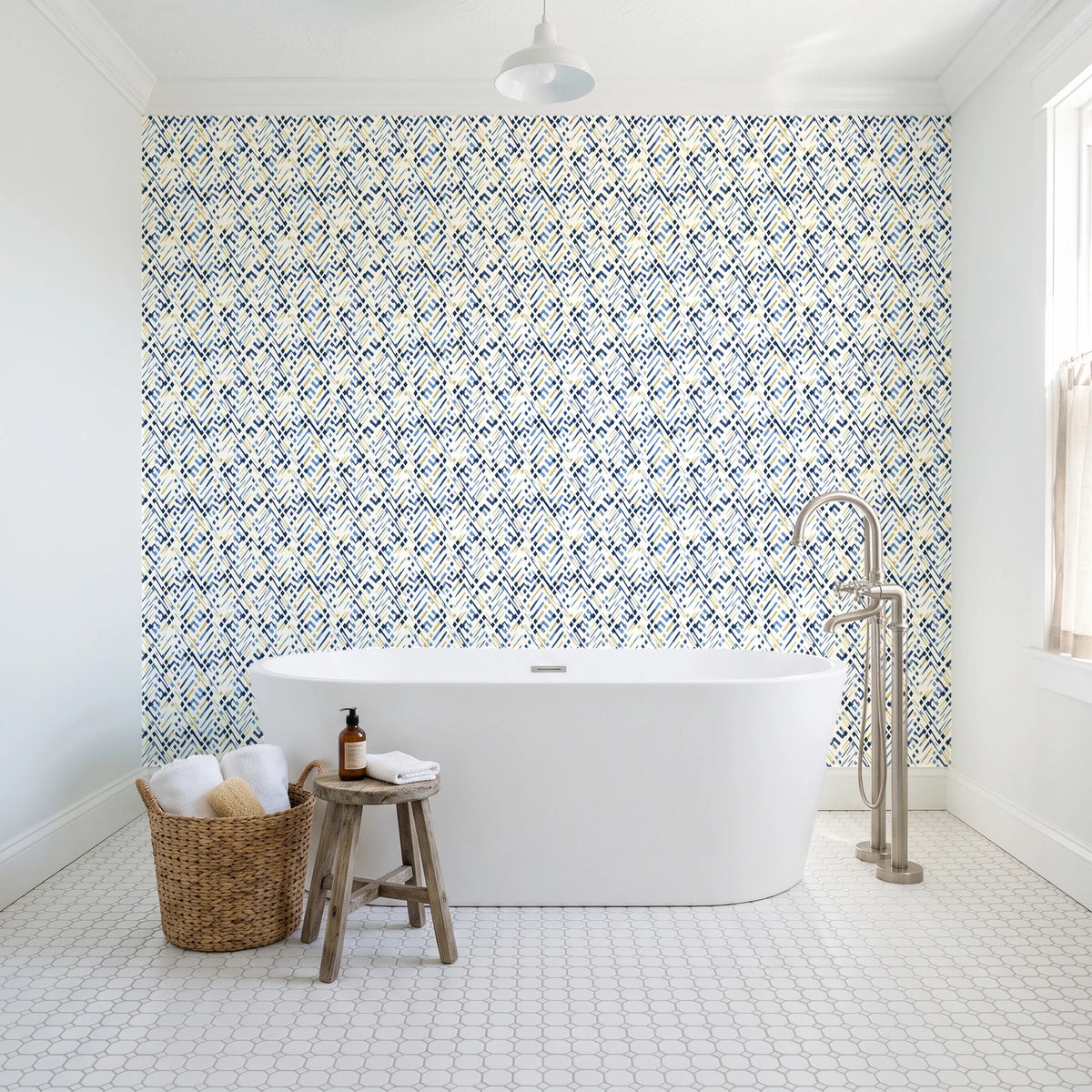 Crossroads Indigo geometric wallpaper behind a freestanding tub in a bright coastal bathroom