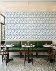 Crossroads Indigo geometric wallpaper above a green leather banquette in a sunlit neighborhood cafe