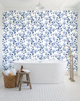 Desert Bloom Indigo botanical vine wallpaper behind a freestanding tub in a bright coastal bathroom