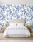 Desert Bloom Indigo botanical vine wallpaper behind a queen bed in a bright coastal bedroom