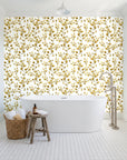 Desert Bloom Ochre botanical vine wallpaper behind a freestanding tub in a bright coastal bathroom