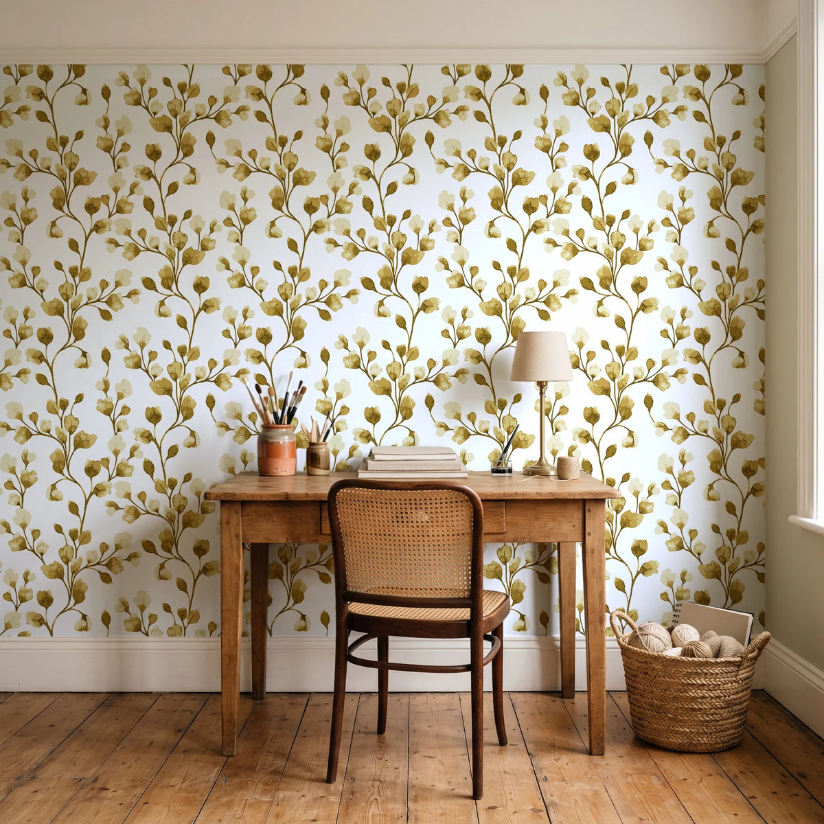 Desert Bloom Ochre botanical vine wallpaper behind a vintage writing desk in a cozy craft-room home office
