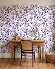 Desert Bloom Plum botanical vine wallpaper behind a vintage writing desk in a cozy craft-room home office