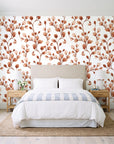 Desert Bloom Terracotta botanical vine wallpaper behind a queen bed in a bright coastal bedroom
