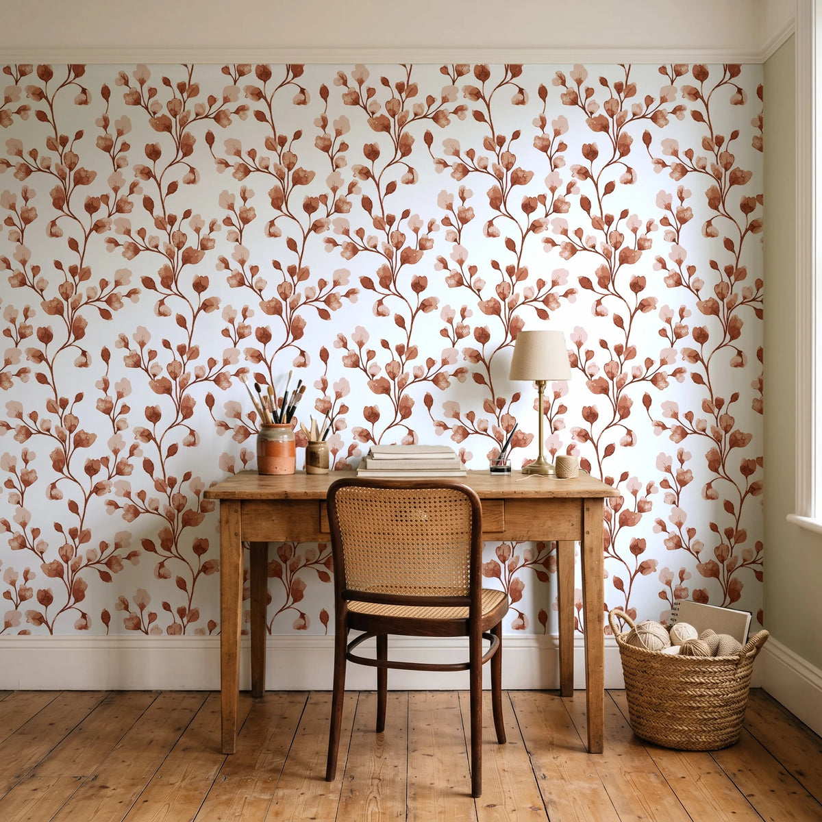 Desert Bloom Terracotta botanical vine wallpaper behind a vintage writing desk in a cozy craft-room home office