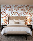 Desert Bloom Terracotta botanical vine wallpaper behind the headboard of a king bed in a contemporary hotel guest room