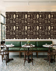 Desert Charms Espresso western icon wallpaper above a green leather banquette in a sunlit neighborhood cafe