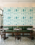 Desert Charms Turquoise western icon wallpaper above a green leather banquette in a sunlit neighborhood cafe
