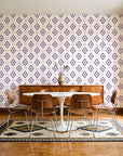 Desert Compass Aubergine geometric diamond wallpaper in a mid-century dining room with a teak sideboard and tulip table