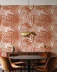Desert Frond Clay palm frond wallpaper behind a walnut credenza and round table in an elegant dining room