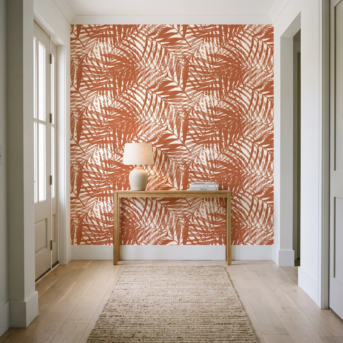 Desert Frond Clay palm frond wallpaper behind a console table in a light entry hallway