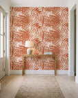 Desert Frond Clay palm frond wallpaper behind a console table in a light entry hallway