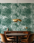 Desert Frond Emerald palm frond wallpaper behind a walnut credenza and round table in an elegant dining room