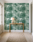 Desert Frond Emerald palm frond wallpaper behind a console table in a light entry hallway