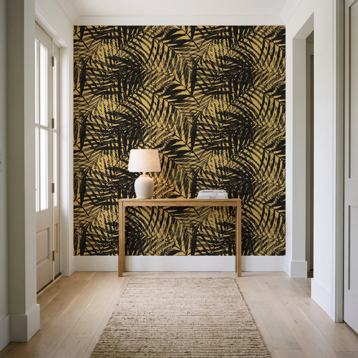 Desert Frond Gilt palm frond wallpaper behind a console table in a light entry hallway