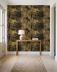 Desert Frond Gilt palm frond wallpaper behind a console table in a light entry hallway