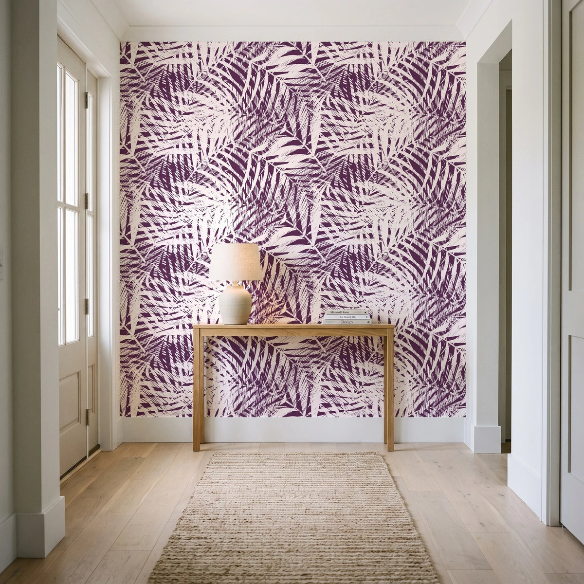 Desert Frond Plum palm frond wallpaper behind a console table in a light entry hallway