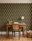 Desert Ritual Noir tribal geometric wallpaper behind a vintage writing desk in a cozy craft-room home office