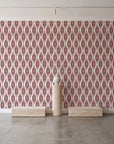 Desert Ritual Oxblood tribal geometric wallpaper behind a travertine pedestal and vase in a minimal boutique