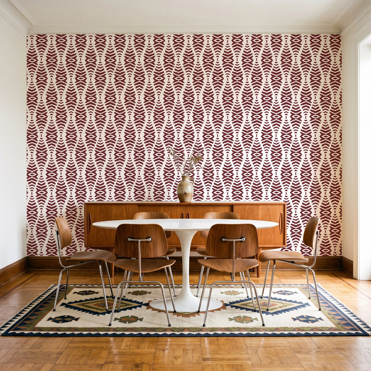 Desert Ritual Oxblood tribal geometric wallpaper in a mid-century dining room with a teak sideboard and tulip table