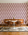 Desert Ritual Oxblood tribal geometric wallpaper in a mid-century dining room with a teak sideboard and tulip table