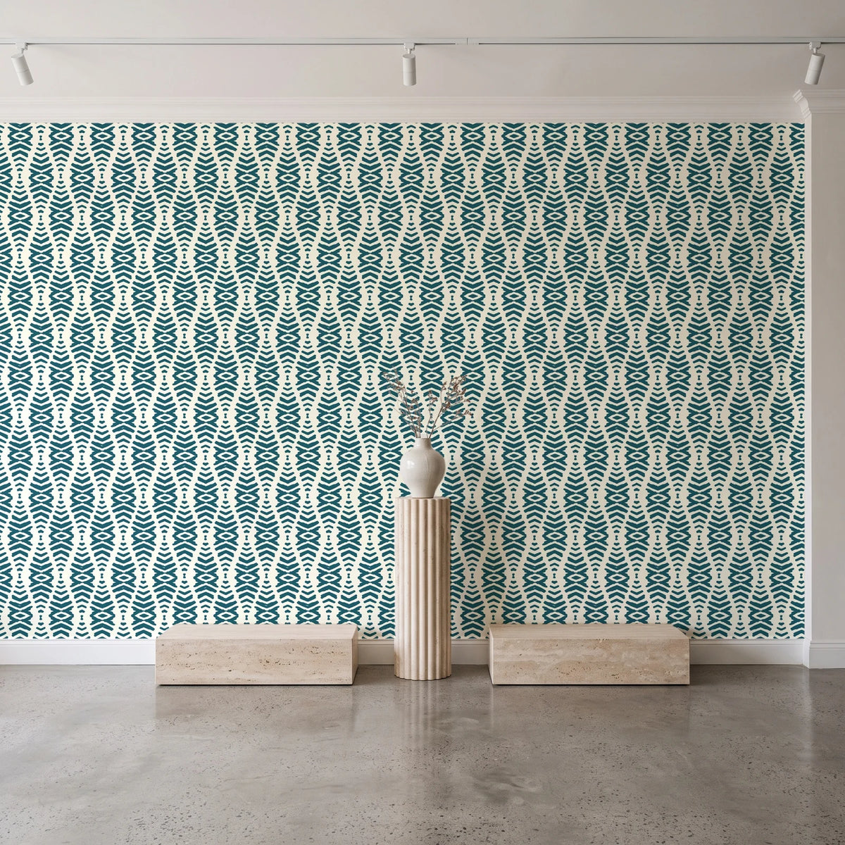 Desert Ritual Peacock tribal geometric wallpaper behind a travertine pedestal and vase in a minimal boutique
