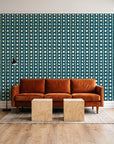 Dot Column Peacock dotted wallpaper behind a rust velvet sofa in a bright coworking lounge