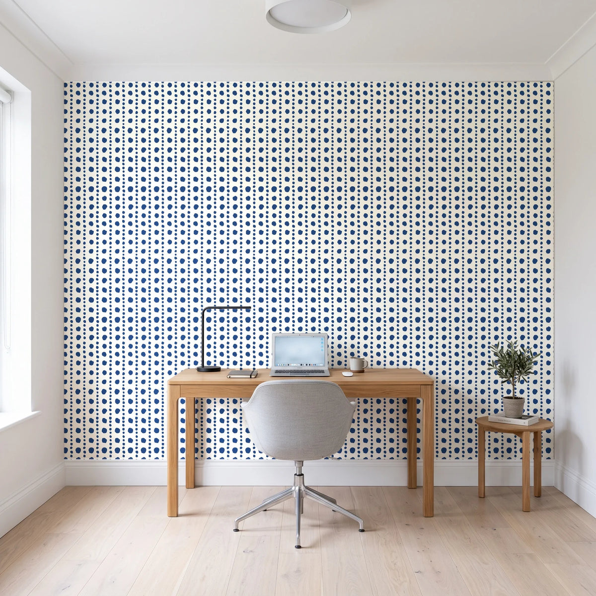Dot Column Porcelain dotted wallpaper behind a modern oak desk in a bright home office