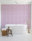 Drifting Petals Plum abstract petal wallpaper behind a freestanding tub in a bright coastal bathroom