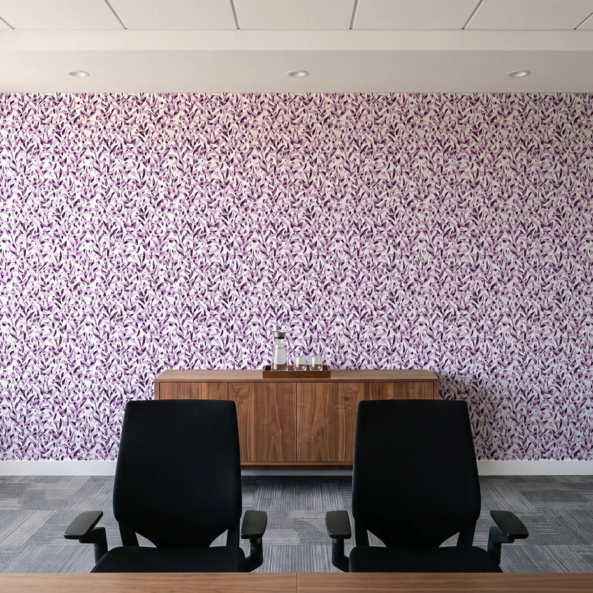 Drifting Petals Plum abstract petal wallpaper above a walnut credenza in a modern conference room